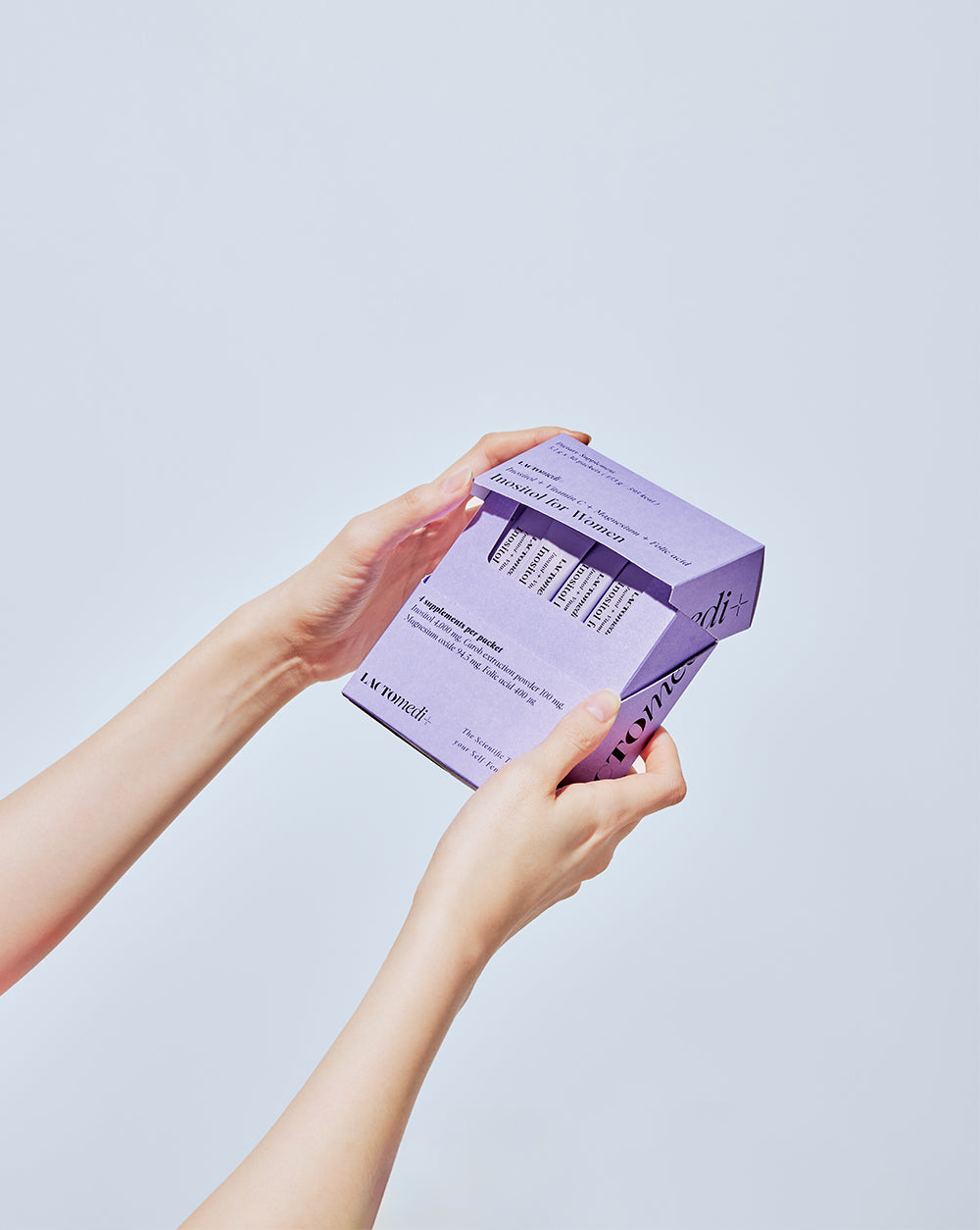 Hands holding a box of Inositol for women